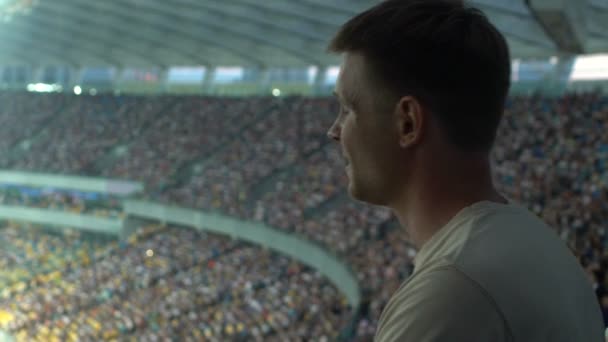 男性の観客がスタジアムでのスポーツ観戦の集中し — ストック動画