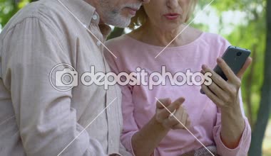 Smartphone touchscreen ile teknoloji kullanmak için yardım yaşlı kadın yaşlı adam