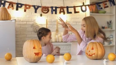 Komik anne küçük kızı için All Hallows Eve kabak hazırlama korkutuyor
