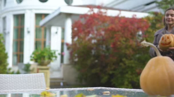 女性カボチャのジャックのテーブルにもたらすの庭で 秋のハロウィーン パーティーのための準備 — ストック動画