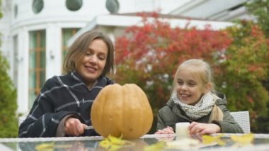 Anne kabak jack-o-lantern carves, kızı mum içinde beraberlik koyar