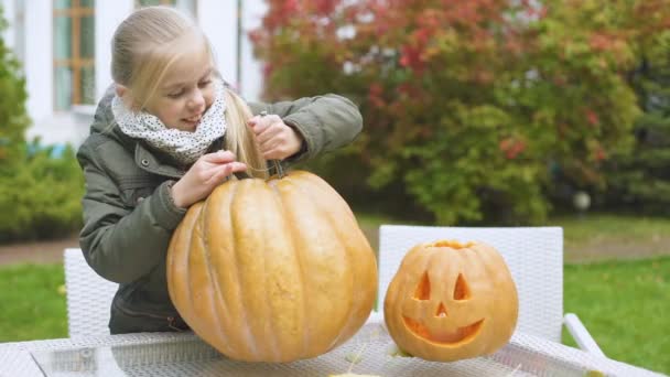 Милая Эмоциональная Девушка Вырезает Тыквенный Валет Фонарь Взволнованный Процессом Хэллоуина — стоковое видео