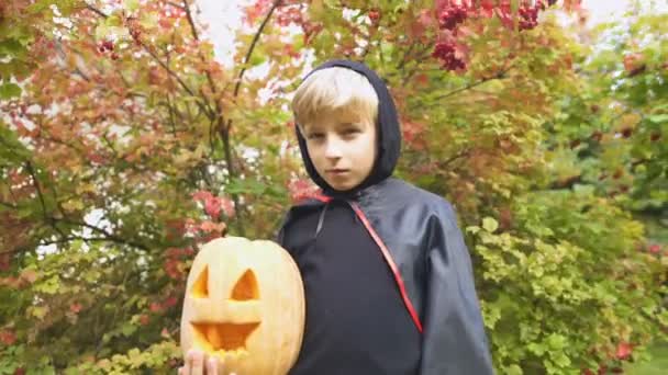 パンプキン ジャック ランタン 森で単独での不気味な保持のハロウィーンの衣装を着た少年 — ストック動画