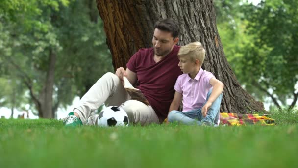 Vader Lezen Boek Met Zoon Park Samen Huiswerk Voorbereiden Ouderschap — Stockvideo