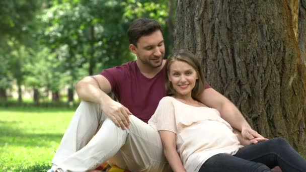 Couple Enceinte Assis Dans Parc Souriant Caméra Maternité Heureuse Rôle — Video