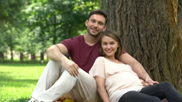 親指を若い家族 福祉に対するソーシャル サポートを示す妊娠中のカップル — ストック動画