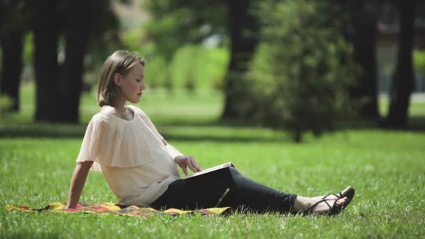 妊娠中の女性は 新鮮な空気を呼吸は 健康的な残りの屋外で本を読んで — ストック動画