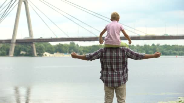 Papá Con Hijo Sobre Sus Hombros Mirando Ciudad Mostrando Fuerza — Vídeos de Stock