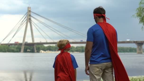 Padre Hijo Vistiendo Divertidos Disfraces Superhéroes Mirando Lejos Padres Apoyo — Vídeos de Stock