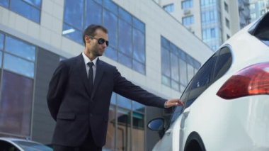 Kapıcı Bayan iş adamları eşliğinde için arabanın kapısını açarak iş merkezi