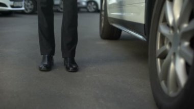 Yüksek topuklu kadın patron, iş görevleri, yakın çekim için arabanın kapısını açarak takım elbiseli adam