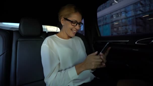 美丽的女商人在她的智能手机上阅读好消息 赢得招标 — 图库视频影像