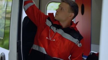 Erkek paramedik radyo tarafından konuşmak çağrı dışarı üstünde götürmek için ambulans kapıyı kapatma