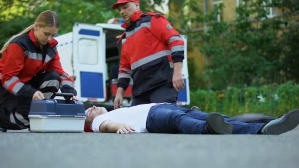 Paramedici Aiutano Uomo Incosciente Sdraiato Sulla Strada Facendo Iniezione Insulina — Video Stock