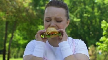 Üzgün kadın tiksinme, irade, lokanta bağımlılığı eksikliği ile hamburger yemek