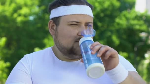 锻炼后喝有活力的饮料恢复水平衡后的胖乎乎的男人 — 图库视频影像