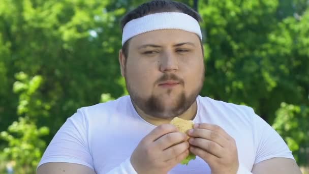 Hombre Gordo Comiendo Hamburguesa Después Del Entrenamiento Adicto Comida Chatarra — Vídeos de Stock