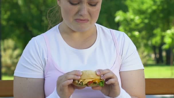 Giovane Donna Che Soffre Desiderio Mangiare Hamburger Fresco Dimenticando Dieta — Video Stock
