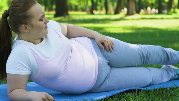 Obese Girl Doing Sport Outdoors Trying Rise Her Leg Weight — Stock Video