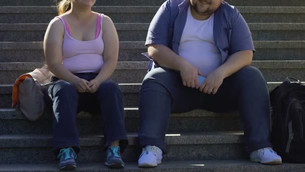 胖乎乎的学生谈笑风生 坐在大学附近的楼梯上 朋友们 — 图库视频影像