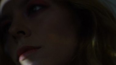 Güzel kadın yüzü tarafından renkli ışık ışınları karanlık, closeup aydınlatılmış