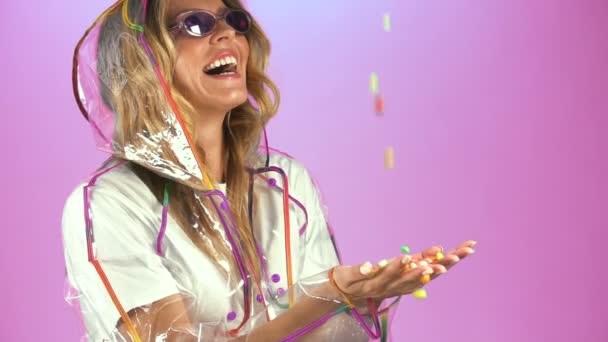 Kobiety Przejrzystych Płaszcz Szczerze Uśmiechnięty Łapanie Kolorowych Cukierków Deszcz — Wideo stockowe