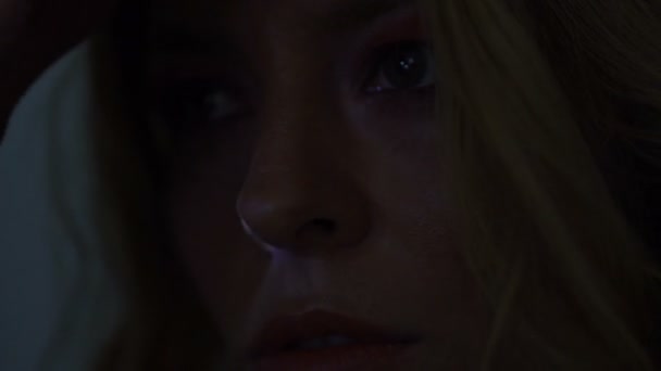 Rayons de lumière colorés illuminant le visage de la jeune femme, obscurité solitude 