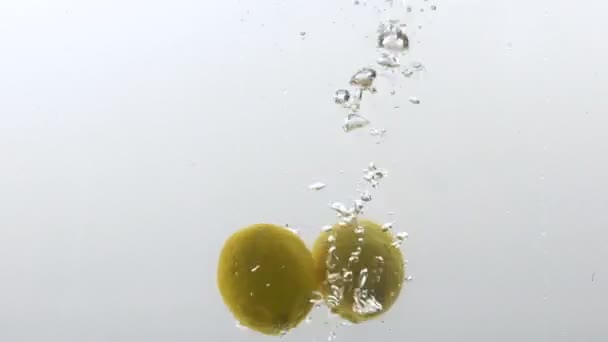 Šťavnaté čerstvé citrony pádu do vody, bioovoce vitamíny, zdravá výživa