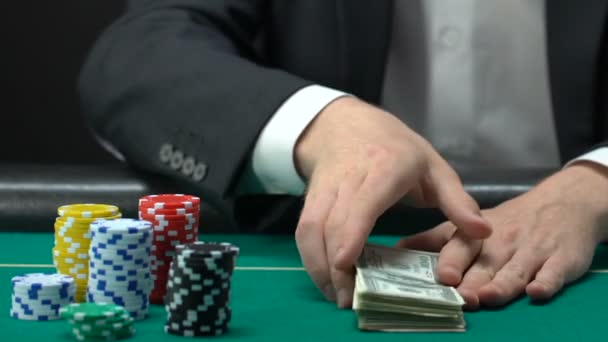 カウント ドルのカジノで座っている若い男を獲得のお金の素晴らしい和の不正行為 — ストック動画