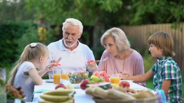 Avô Contando História Engraçada Para Netos Enquanto Come Relações Familiares — Vídeo de Stock