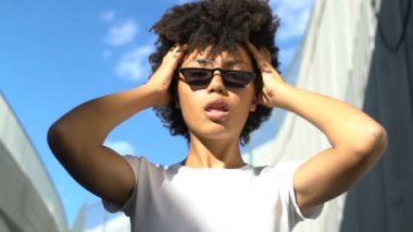 Onun tarzı, moda seçtiğiniz kamera için poz serin bardaklarda biracial modeli