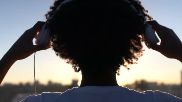 Sihirli Saat Koyarak Kulaklıktan Kıvırcık Saçlı Kadının Silüeti — Stok video