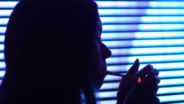 若い女性照明タバコとナイトクラブで休んで吸入の苦い煙 — ストック動画