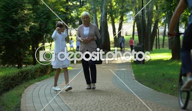 Mutlu kız parkta yürüyüş Büyükanne ilişkilerin güvenerek hikayeler anlatmaya