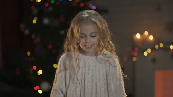 小金发女孩拿着礼物在圣诞树下 神奇的冬天的气氛 — 图库视频影像