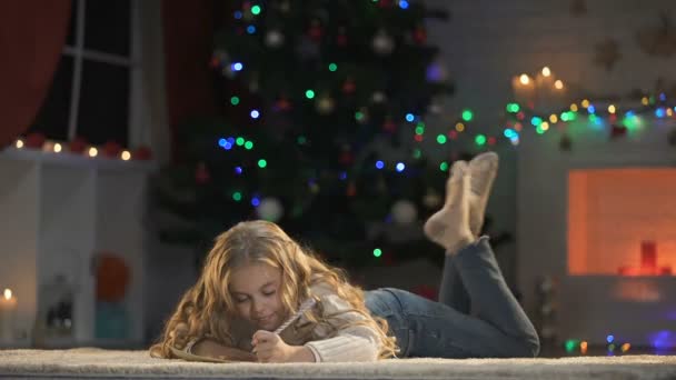 漂亮的女孩在闪亮的装饰下为父母准备圣诞礼物 — 图库视频影像
