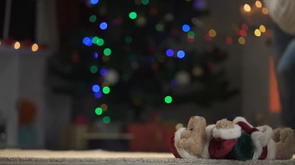 かわいい女の子再生と輝くクリスマス ツリー サンタ衣装でテディベアを抱いて — ストック動画
