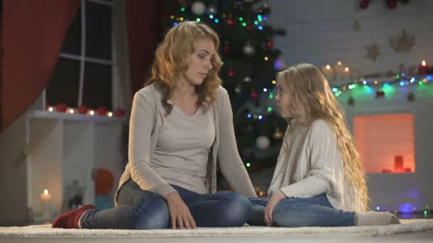 かわいい女の子の行方不明の父と抱き締めるママ 美しいクリスマス ツリーのそばに座って — ストック動画