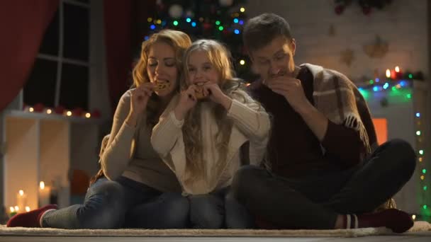 Familia Comiendo Galletas Dulces Suelo Árbol Navidad Luces Brillantes Víspera — Vídeos de Stock