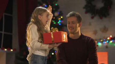 Noel mutlu baba için mevcut veren sevimli küçük kızını ışıklar pırıl pırıl