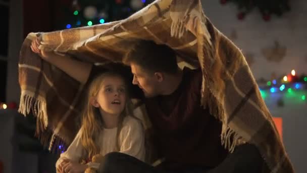 Glückliches Mädchen Das Papas Geschichte Hört Unter Kariertem Weihnachtsbaum Sitzend — Stockvideo