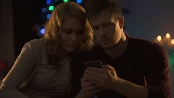和平的男友和女朋友在圣诞前夜在电话里阅读信息 — 图库视频影像