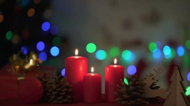 Arka plan üzerinde köpüklü ahşap Noel süslemeleri ışıkları yakın yanan mumlar