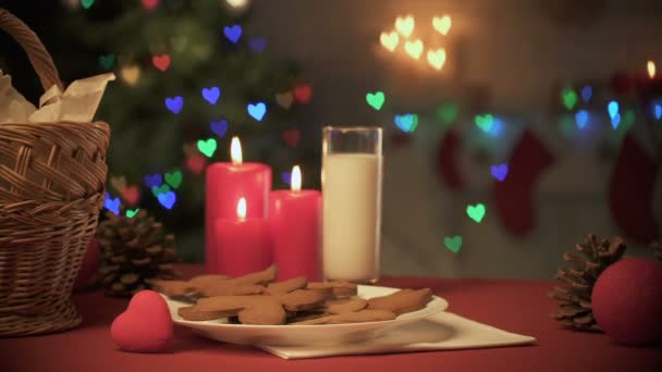 桌上一杯牛奶和姜饼 圣诞树上灯火通明 — 图库视频影像