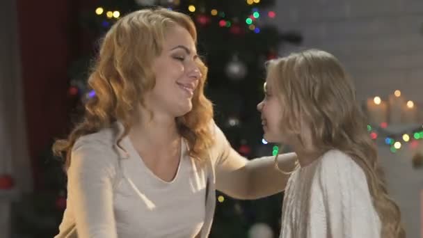 可爱的母亲和女儿拥抱在被照亮的圣诞树的背景下 — 图库视频影像