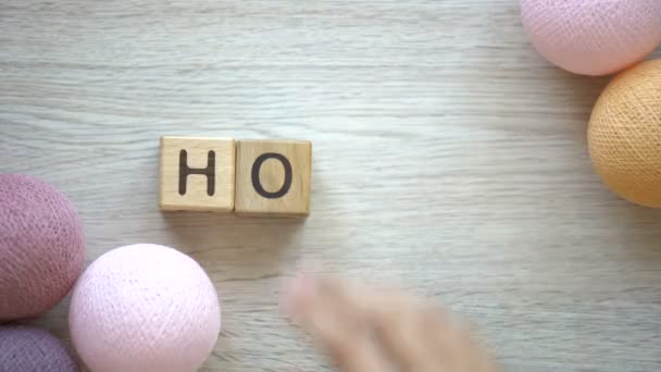 木製キューブ テーブルに横になっているカラフルなスレッド ボールの単語を作る女性 — ストック動画