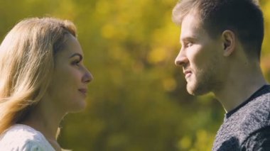 Genç çift öpüşme, adam yüzleri sonbahar yaprak, romantik tarih, closeup ile gizleme
