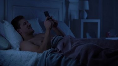 Genç erkek manifatura smartphone ve gülümseyen, kız arkadaşıyla sohbet aracı