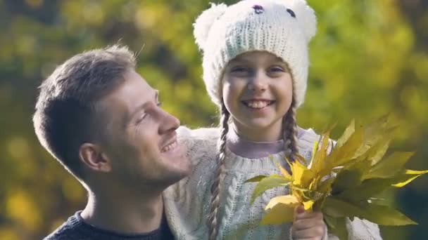 女孩拿着秋叶花束 父亲亲吻女儿的脸颊 特写镜头 — 图库视频影像