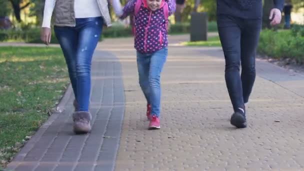 幸せな女の子の学校の後 親と歩いて面白いクラスを誇る — ストック動画